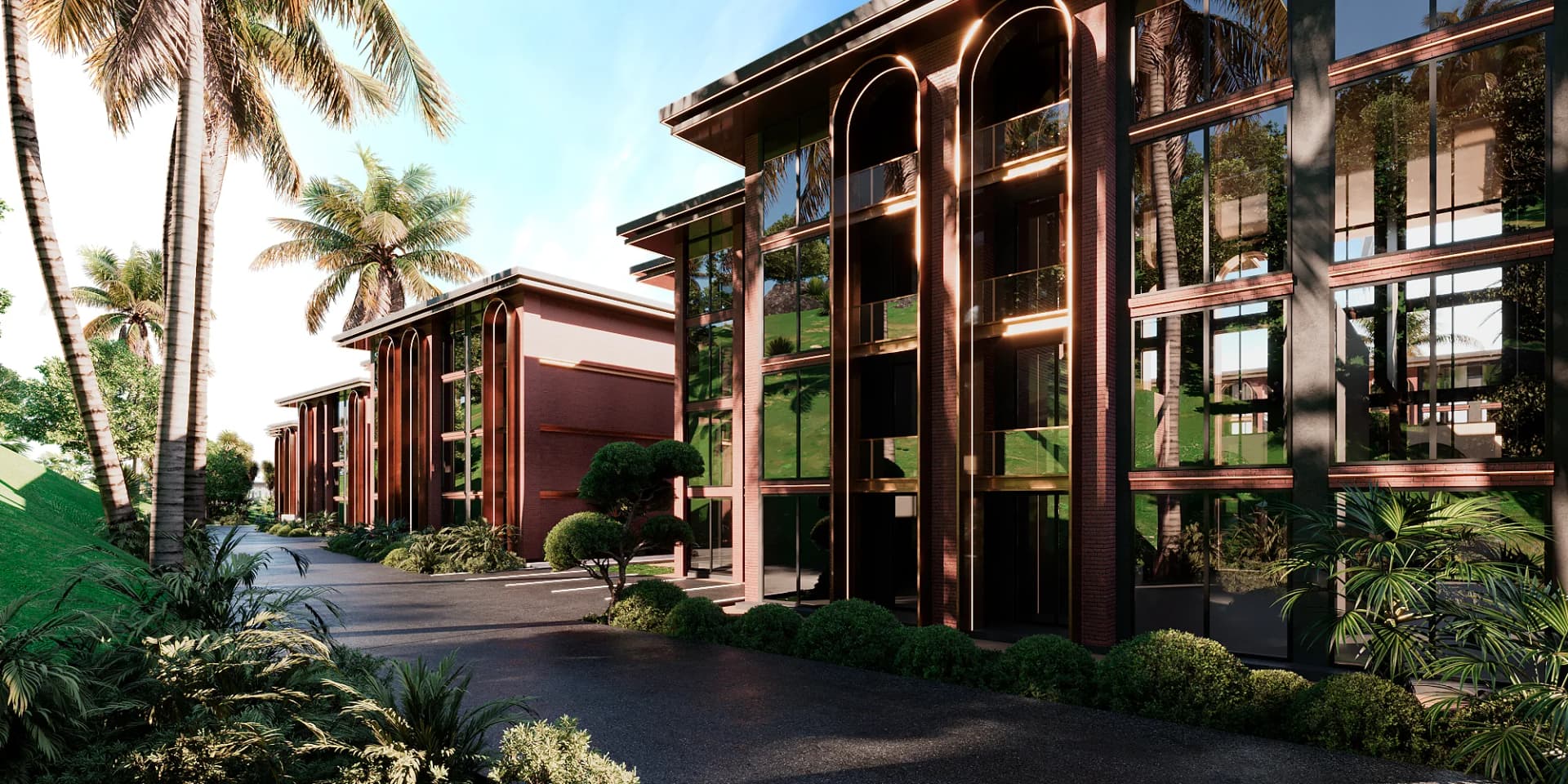 A brick-and-glass block seen past tropical planting, its arched windows in the sun